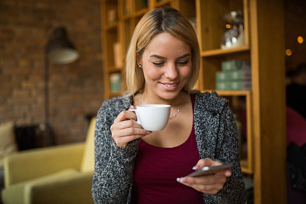 istock Smiling woman reading text messaging on mobile phone 520015062