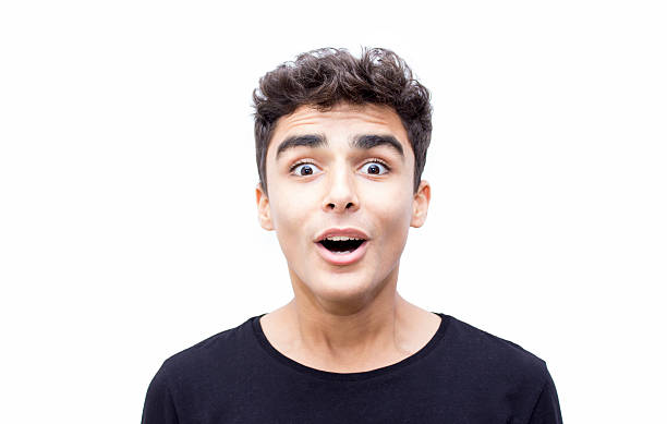 Portrait of shocked boy over white background Portrait of surprised teenage boy looking at camera over isoalted on white. Horizontal composition. Studio shot. mouth open stock pictures, royalty-free photos & images