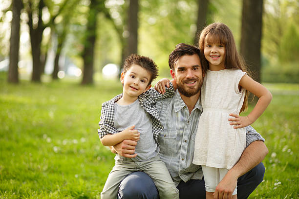 istock Cheerful father with two children in park 520015996