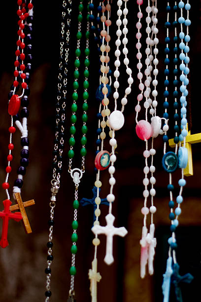 istock Bright Rosary Beads and Crucifixes Hang Against Black Background 520017012