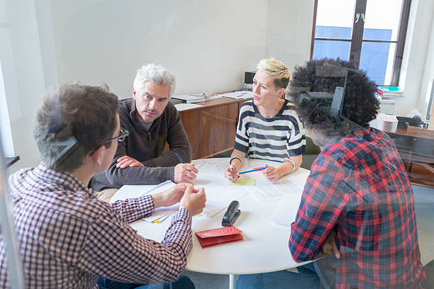 istock Four people at a business meeting viewed through a window 520018107