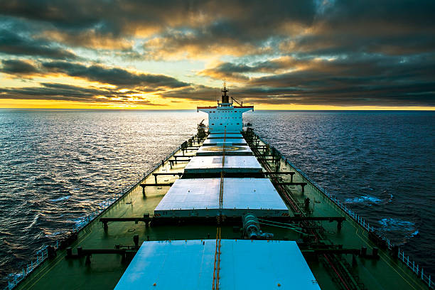 Cargo ship underway at sunset stock photo