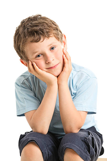istock sad 7 years old boy sitting isolated picture 520018775