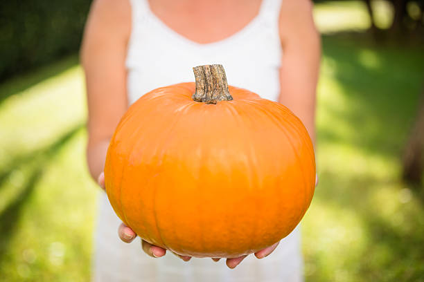 istock woman holding an halloween pumpkin 520018819