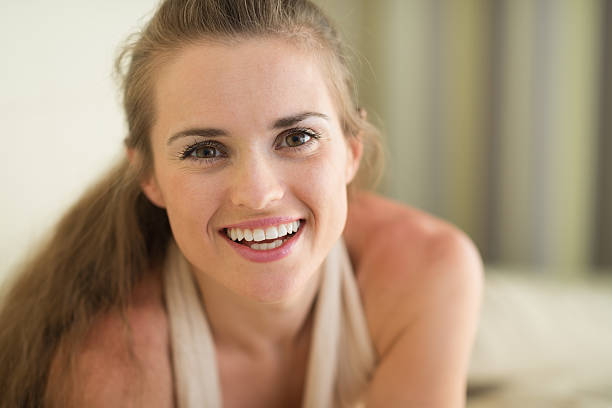 istock smiling young woman laying on couch 520021003
