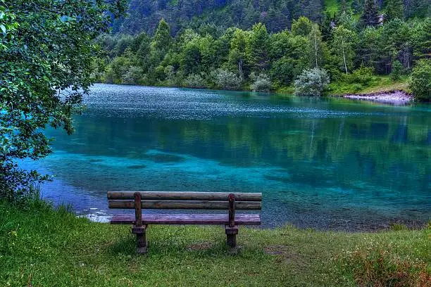 a bench on the turquoise lake