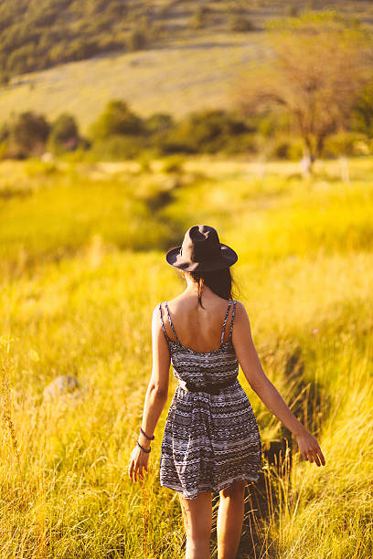 istock Young woman enjoying a walk in the sunny meadow 520021997