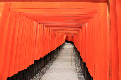 Kyoto, Japan - May 27, 2013: Fushimi Inari Shrine is an important Shinto shrine in Southern Kyoto, Japan. It is famous for its thousand of vermilion torii gates, which straddle a network of trails behind its main buildings. The trails lead into the wooded forest of the sacred Mount Inari, which stands at 233 meters and belongs to the shrine grounds.