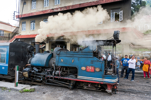 Darjeeling,India - May 21, 2012: Darjeeling, West Bengal, India - May 21th, 2012: Steam engine of old Toy Train (N.F.791A)in the city of Darjeeling; people walking .