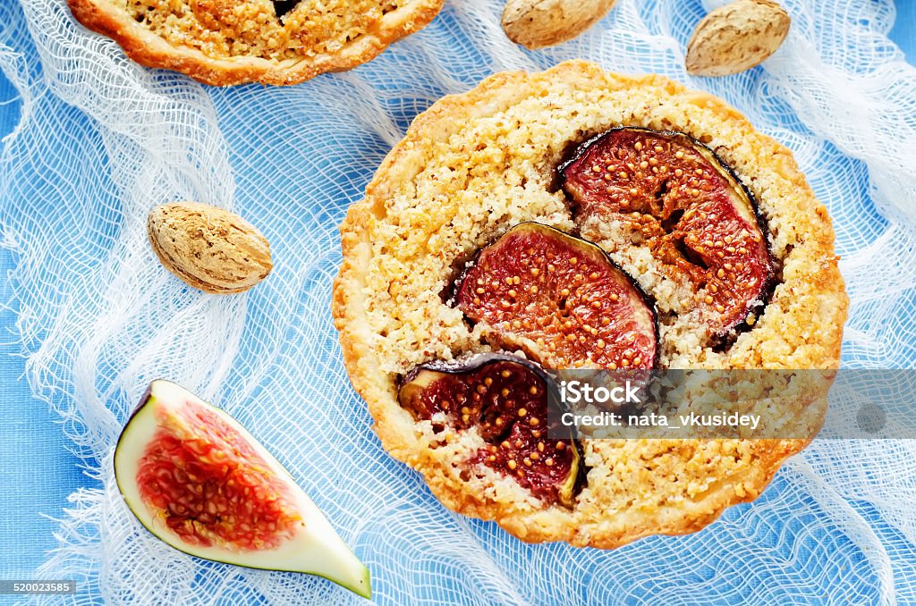 tartlets with Fig and almond cream (Frangipane) tartlets with Fig and almond cream (Frangipane) on a light blue background. tinting. selective focus on the left tartlet Almond Stock Photo