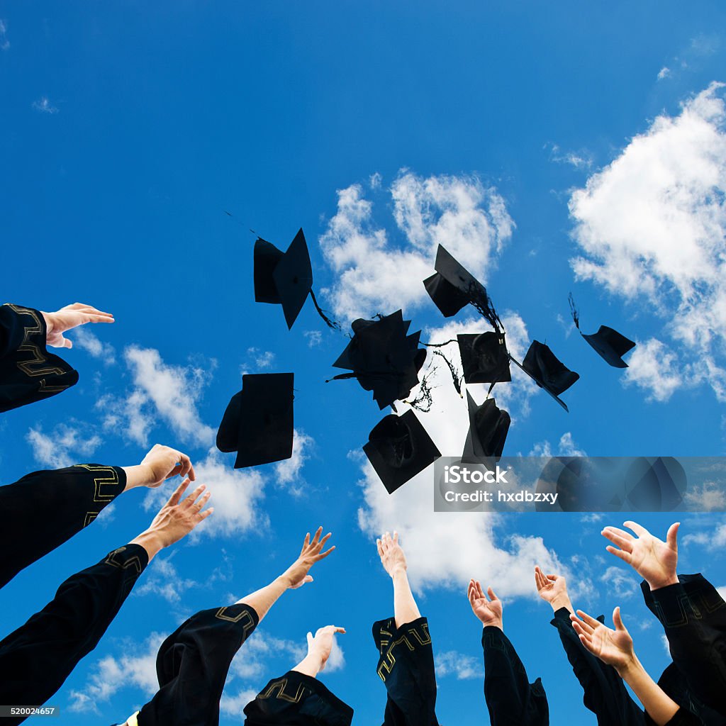 hat toss high school graduates tossing up hats over blue sky. Mortarboard Stock Photo