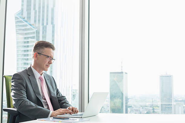 istock Mature businessman using laptop in office 520025483
