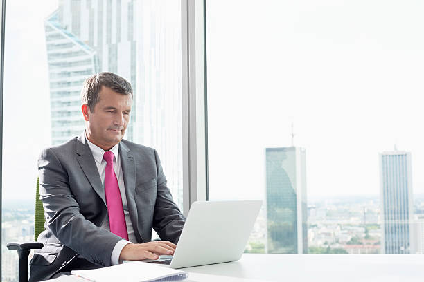 istock Mature businessman using laptop in office 520025487