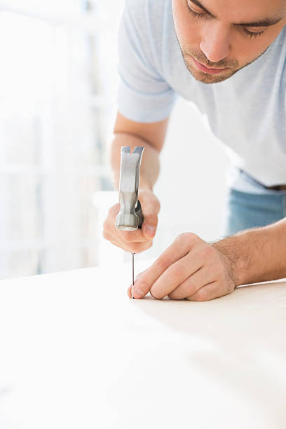 istock Mid-adult man nailing in table 520039707