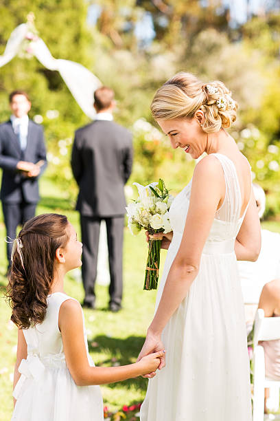istock Bride And Flower Girl Looking At Each Other 520042173