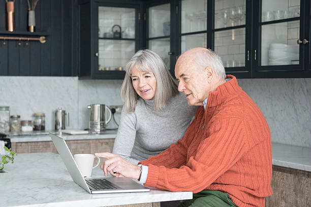 istock Senior man and woman using laptop at home together 520047242