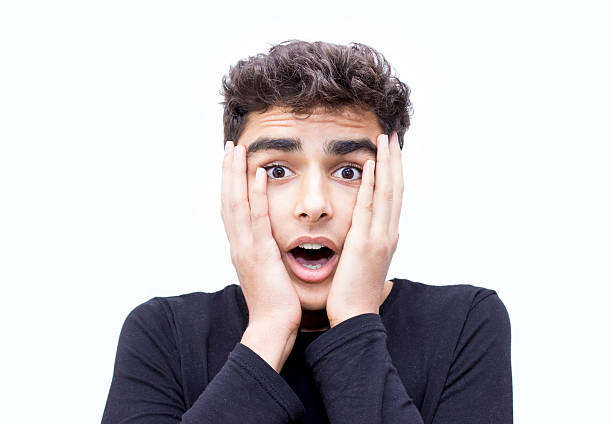 Portrait of shocked teenage boy over white background Portrait of shocked teenage boy over white background. Young man looking at camera with frustrated, shocked facial expression over isolated on white. Horizontal composition. Studio shot. Image developed from RAW format. confusion raised eyebrows human face men stock pictures, royalty-free photos & images