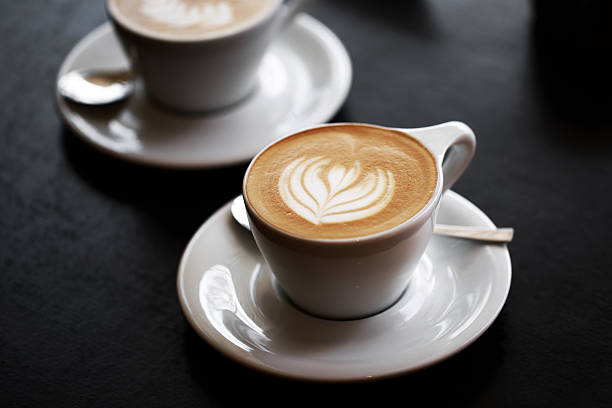 istock Two cups of cappuccino on black table 520052518