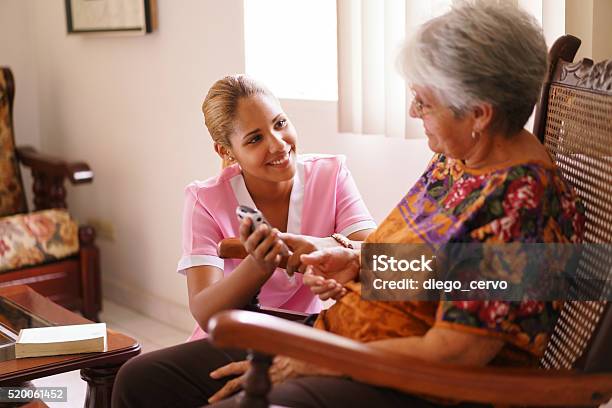 Hospice Nurse Helps Old Lady With Mobile Phone Call Stock Photo - Download Image Now
