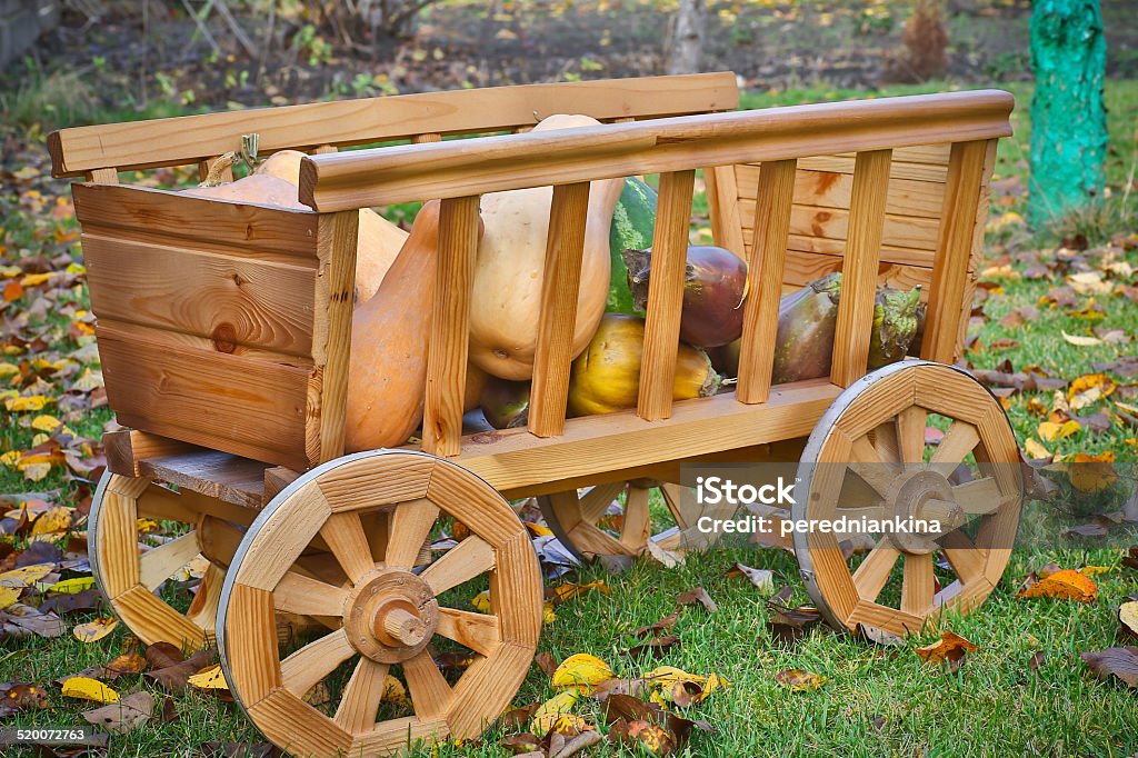 harvest pumpkins in a wooden cart harvest pumpkins in a wooden cart of fallen autumn leaves Autumn Stock Photo
