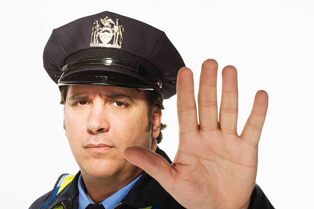 istock Police officer signaling stop, close-up, portrait 520073775