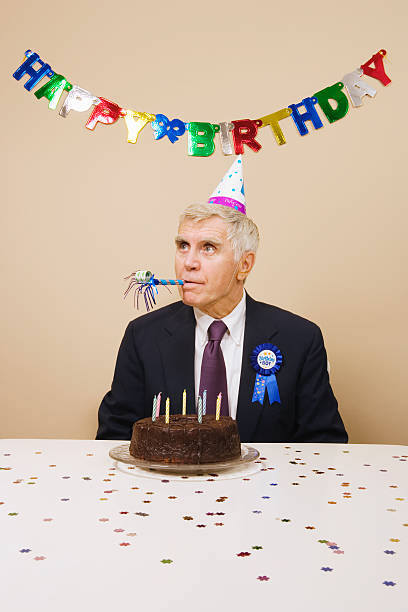 hombre mayor celebrar un cumpleaños, en el interior del hotel - birthday favors fotografías e imágenes de stock