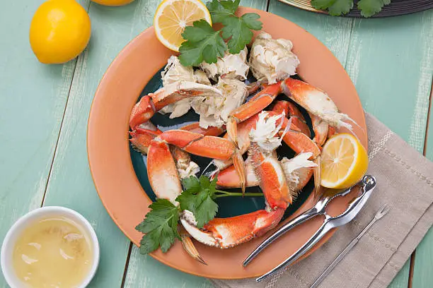 Assorted Dungeness crab legs with butter mustard sauce and fresh lemons..