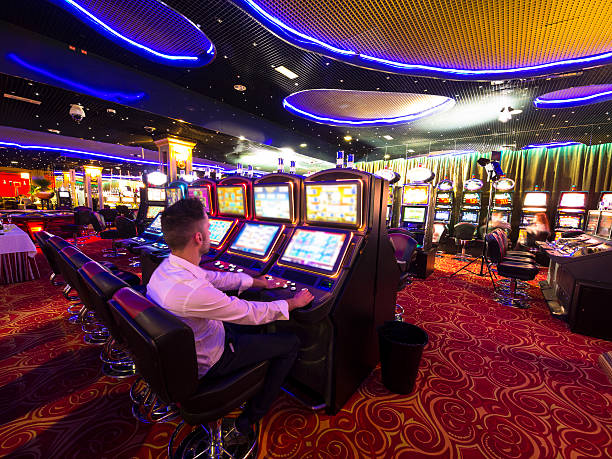 junger mann am spielautomaten im kasino - playing chance gambling house stock-fotos und bilder
