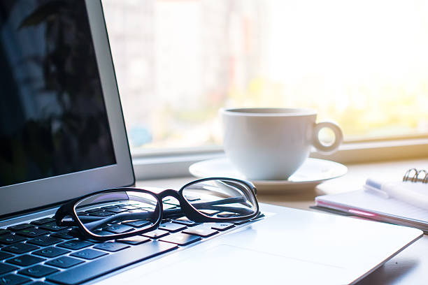 istock Eyeglasses and laptop on office desk 520092154