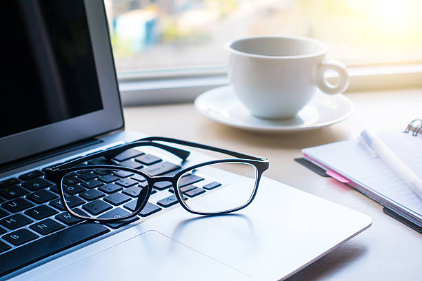 istock Eyeglasses and laptop on office desk 520093282