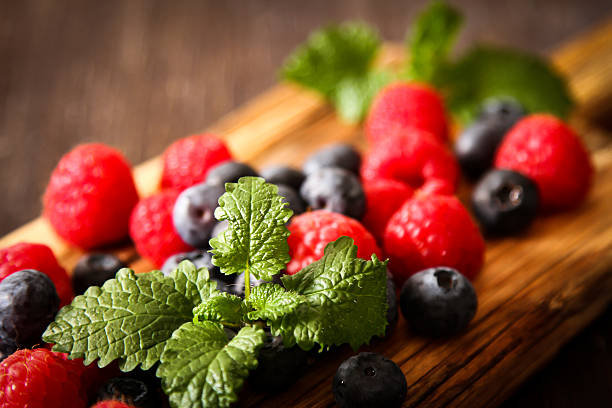 istock blueberries and raspberries on a wooden board background wood da 520093790