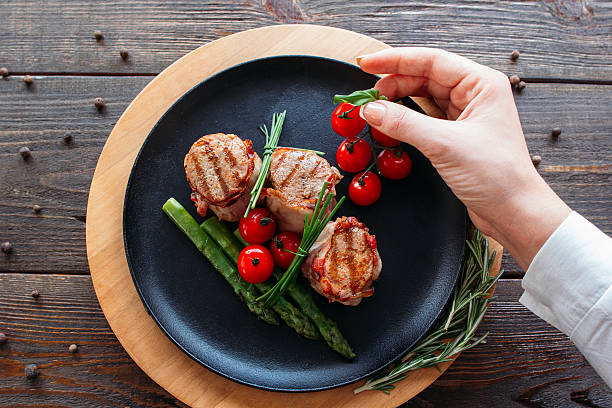 istock Food  stylist. Chef decorating a pork dish. 520095720