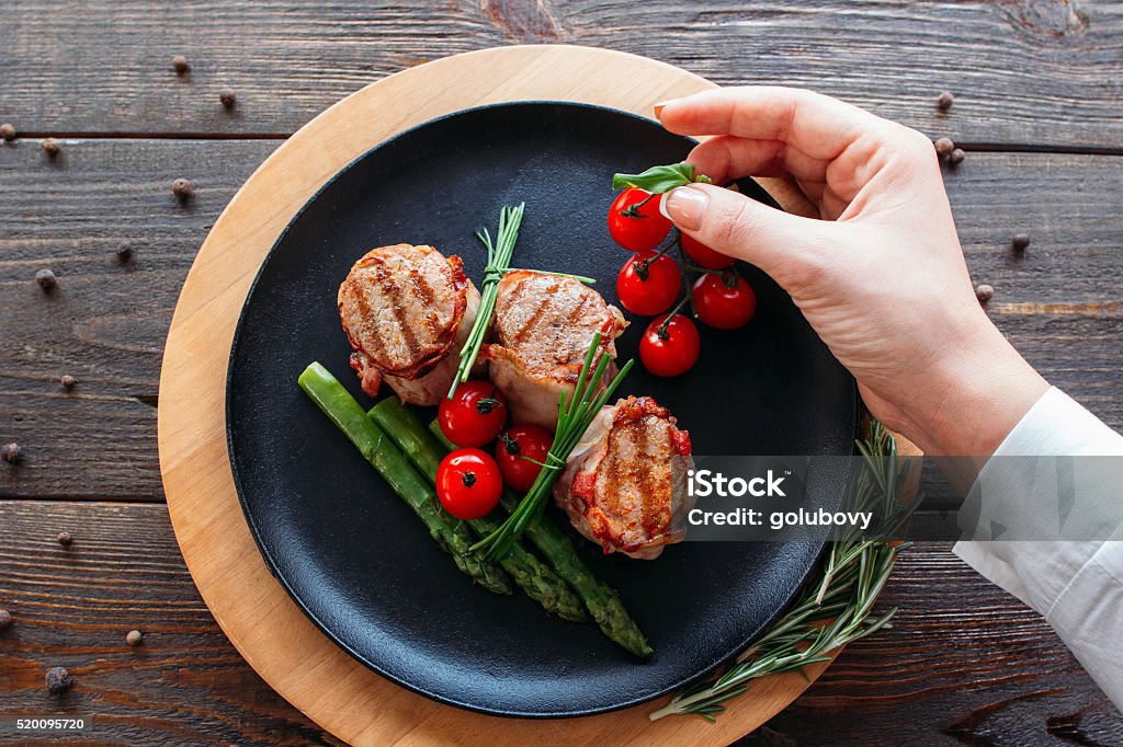 Estilista de alimentos. Cozinheiro chefe Decorando um prato de carne de porco. - Foto de stock de Cozinhar royalty-free