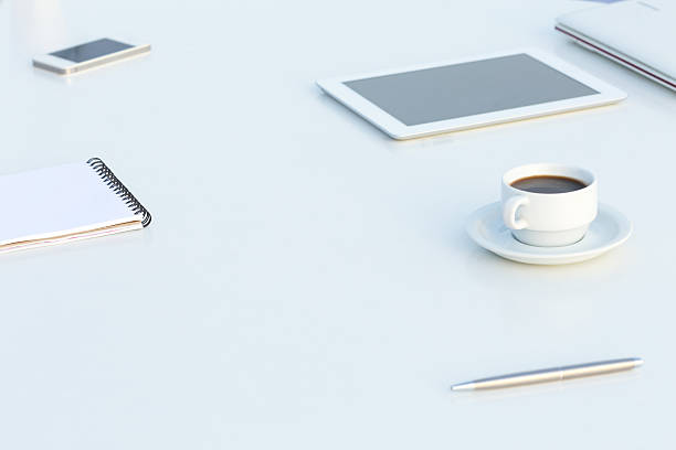 White working Place with Electronic Gadgets Paper Notepad Pen and Coffee in soft Tones with Copy Space