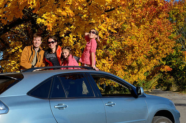 Car trip on autumn family vacation, happy parents and kids travel and have fun, car insurance concept