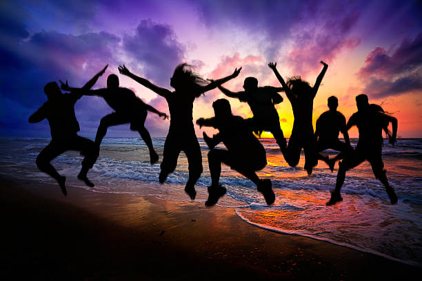 istock Spring break backlit group of young people jumping on beach 520118521