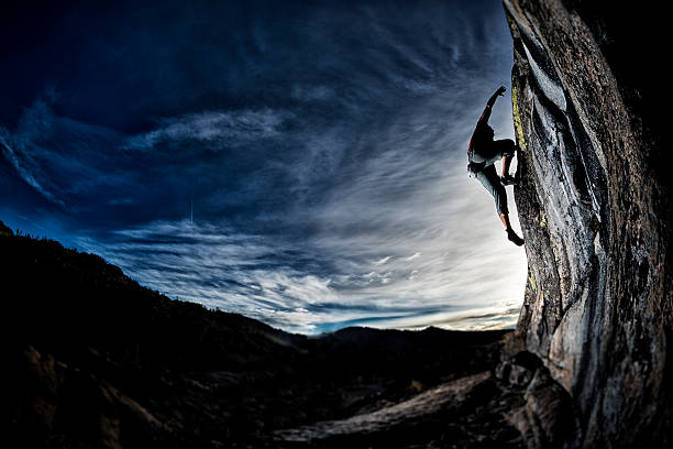 fit man rock climbing al atardecer - escalada en solitario fotografías e imágenes de stock