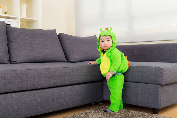 Baby with dinosaur dressing at home