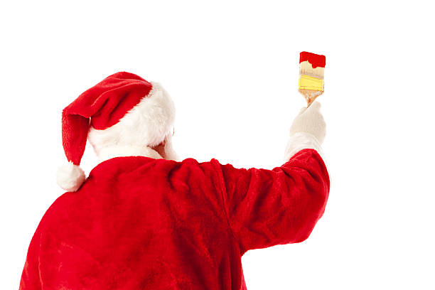 Subject: A rear view of Santa Claus as he carries a heavy burlap bag of Christmas gifts over his shoulder, on his back. Isolated on a white background.