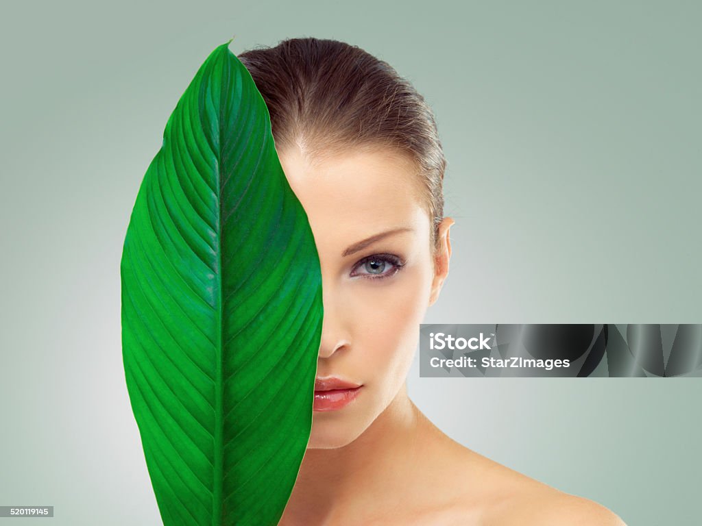 Nature's beauty benefits Studio portrait of a beautiful young woman with her face partially covered by a large green leafhttp://azarubaika.com/iStockphoto/2014_05_09_Victoria_Beauty.jpg Women Stock Photo