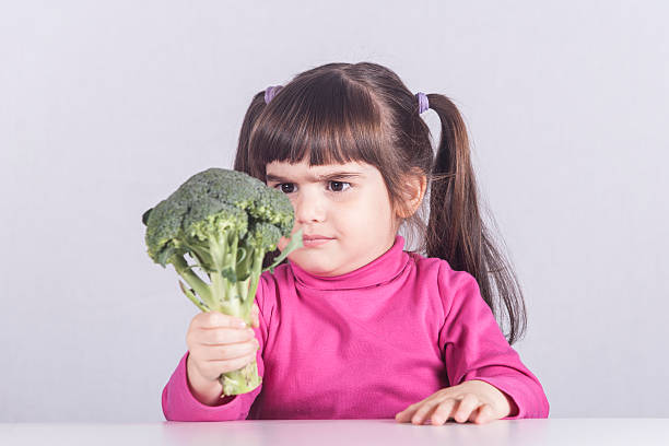 istock Little girl refusing to eat her vegetables 520124812