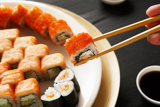 istock Eating sushi rolls at japanese food restaurant 520127306