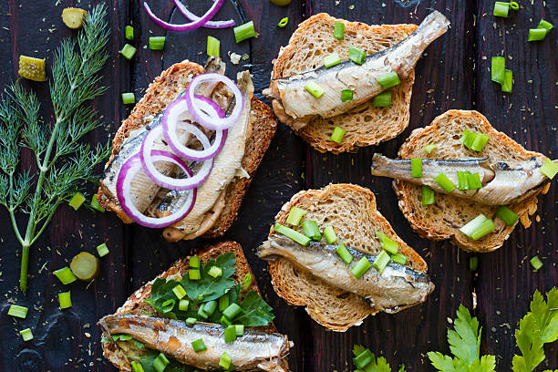 istock sandwich with sardines, sprinkle with onions on a black background 520127828