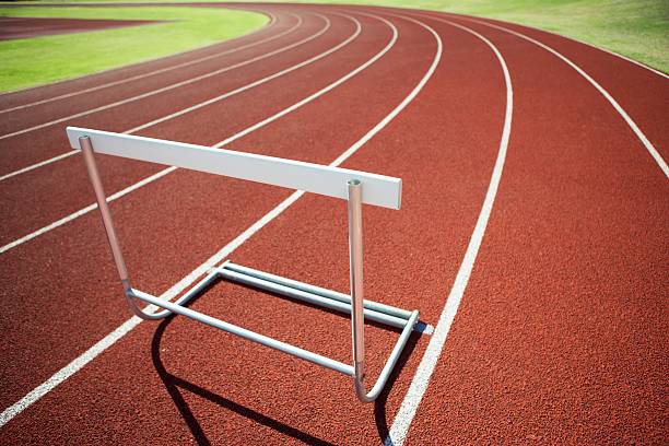 valla en una pista de atletismo - hurdle fotografías e imágenes de stock