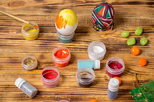 istock process of painting easter eggs, paint cans, glitter 520130412