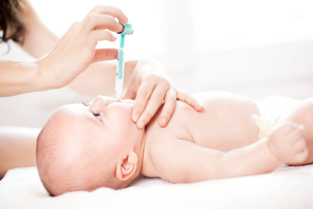 bebé s'administró medicamento por vía oral - vacunación antipoliomielítica fotografías e imágenes de stock