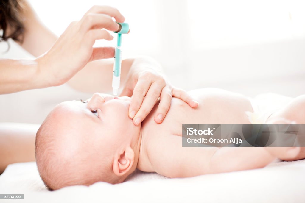 Baby being given medicine through mouth Baby boy being given medicine through mouth Polio Vaccine Stock Photo