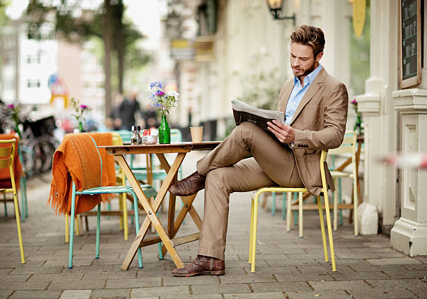 Young man reading a newspaper in a street