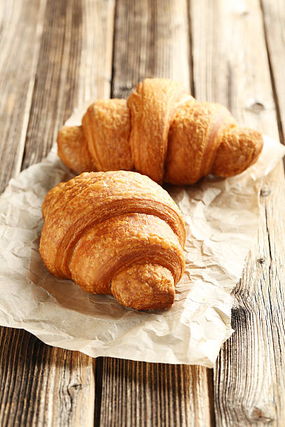istock Tasty croissants on brown wooden background 520132600