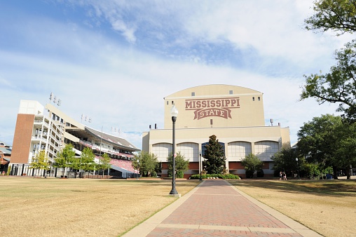 Mississippi State University, Mississippi, USA - October 18, 2014: Looking down sidewalk from the junction towards the sound side of Davis Wade Stadium on the campus of Mississippi State Unviersity, located near the town of Starkville, Mississippi.  View shows MSU sign on south end zone building.